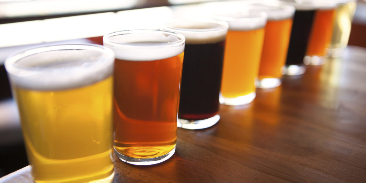 Eight beer samplers lined up on a table